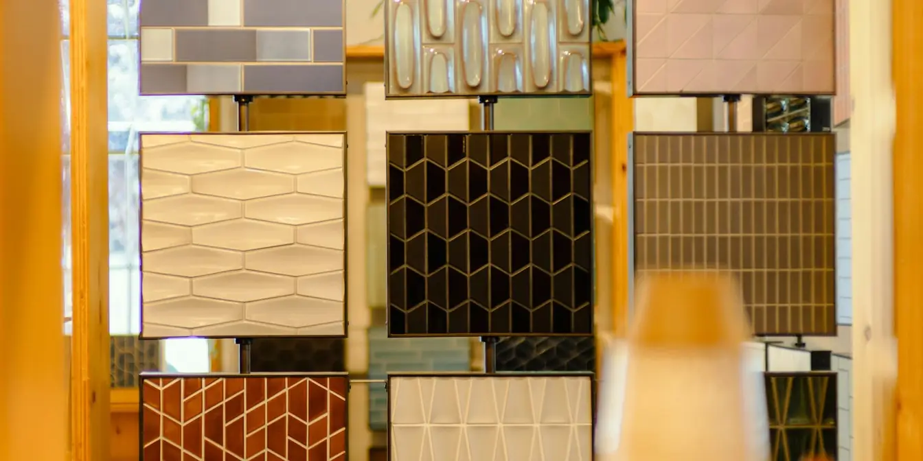 Panels of ceramic tile samples in different shapes and glazes on display in a showroom